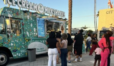photo of people waiting in line in front of a food truck selling ice cream and milkshakes