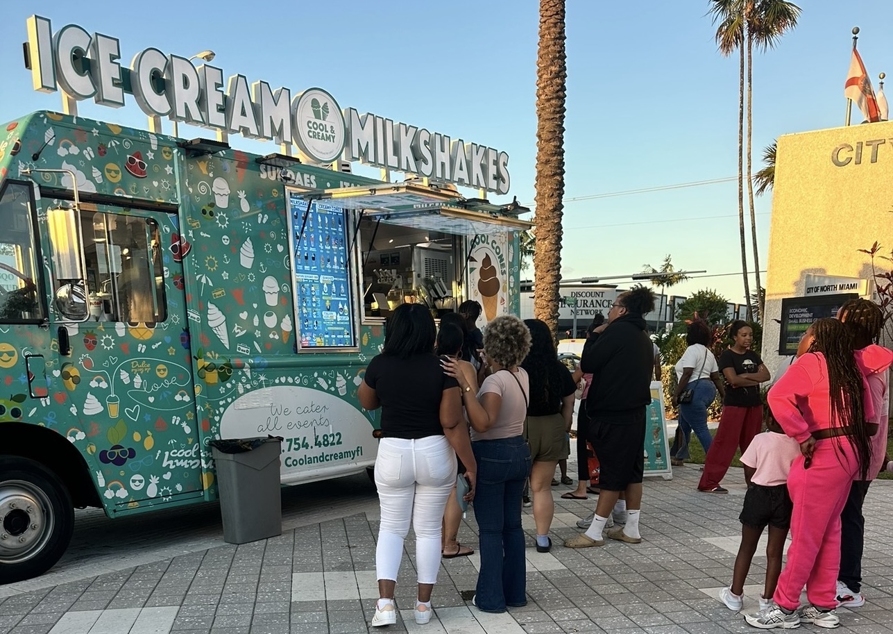 photo of people waiting in line in front of a food truck selling ice cream and milkshakes