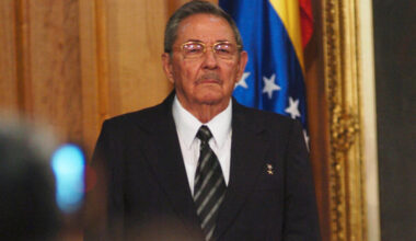 Former Cuban President Raul Castro wearing a dark suit flag during a formal government or diplomatic event.