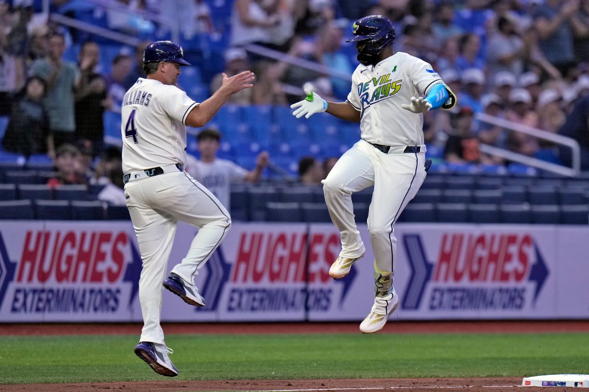 Tampa Bay Rays' Junior Caminero celebrates his solo home run off San Francisco Giants pitcher Robbie Ray with third base coach Brady Williams (4) during the fourth inning of a baseball game Friday, May 1, 2026, in St. Petersburg, Fla. (AP Photo/Chris O'Meara)
