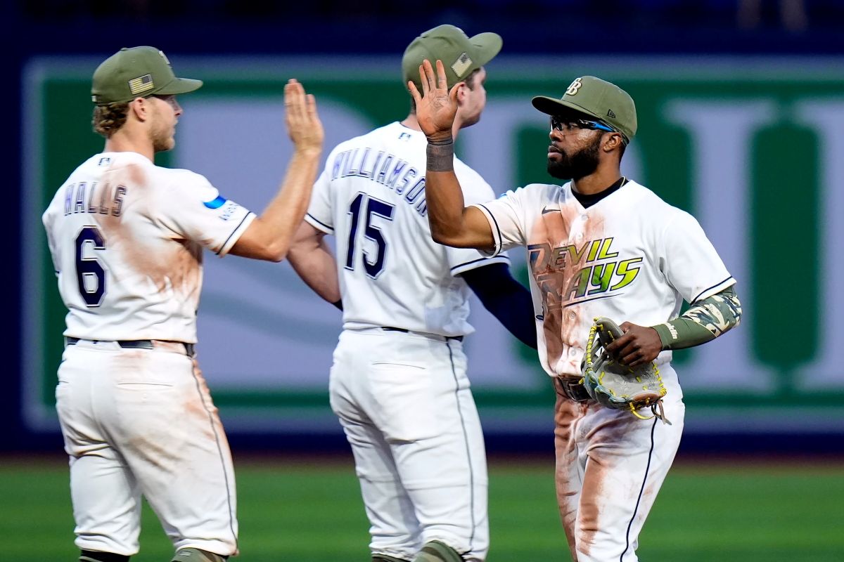 Tampa Bay Rays center fielder Cedric Mullins celebrates with shortstop Taylor Walls (6) and second baseman Ben Williamson (15) after the team defeated the Miami Marlins during a baseball game Friday, May 15, 2026, in St. Petersburg, Fla. (AP Photo/Chris O'Meara)