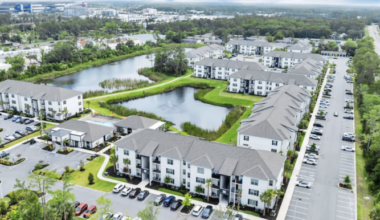 Aerial view of a Hillpointe apartment community featuring multiple three-story residential buildings, ponds, clubhouse amenities and surface parking.