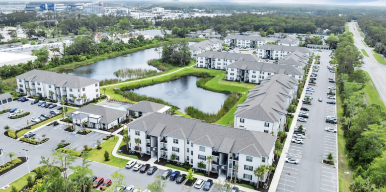 Aerial view of a Hillpointe apartment community featuring multiple three-story residential buildings, ponds, clubhouse amenities and surface parking.