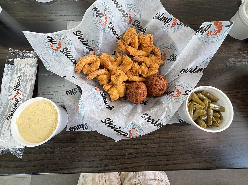A meal of shrimp, hush puppies and two sides - here, cheese grits and green beans - is priced at $13. A meal of shrimp, hush puppies and two sides - here, cheese grits and green beans - is priced at $13.