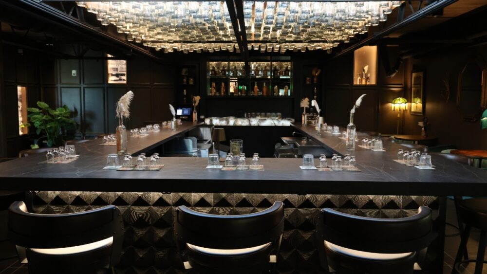 Bar seating and bottle-lit ceiling inside 31 South speakeasy at St. Petersburg Distillery