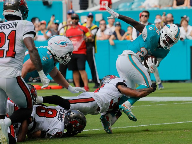 Miami Dolphins running back De'Von Achane (28) runs past the Tampa Bay Buccaneers defense, Sunday, Dec. 28, 2025, at Hard Rock Stadium in Miami Gardens. (Joe Cavaretta/South Florida Sun Sentinel)
