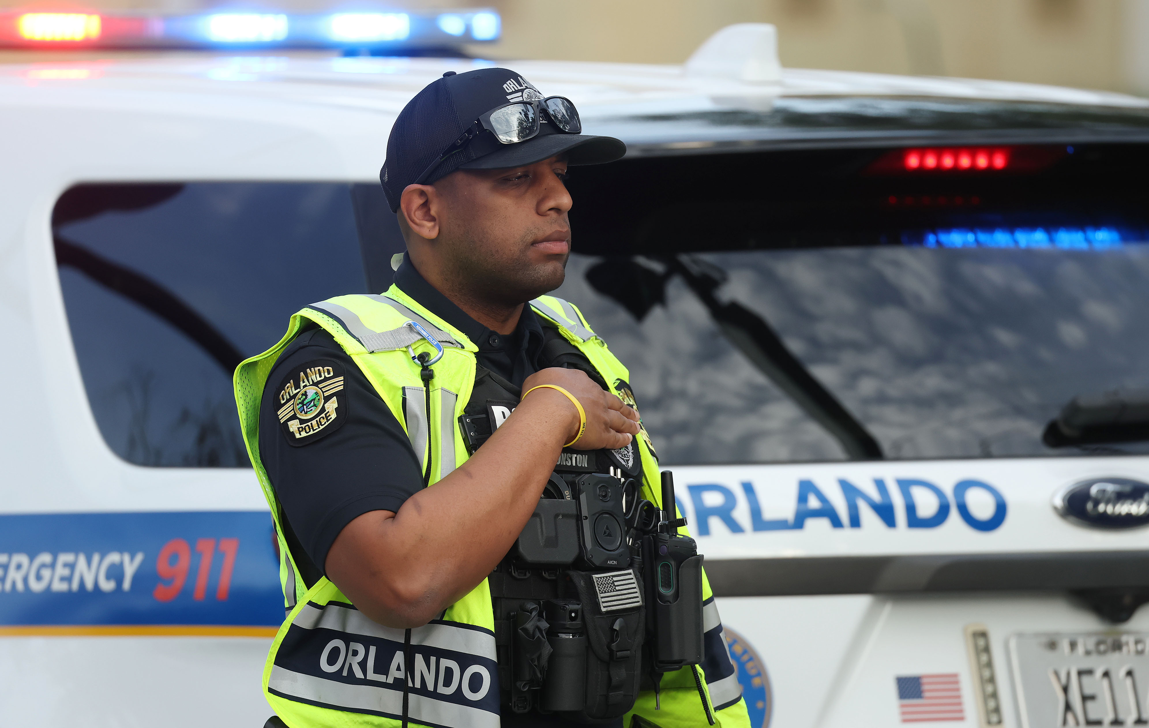 An Orlando police officer stands with his hand on his...