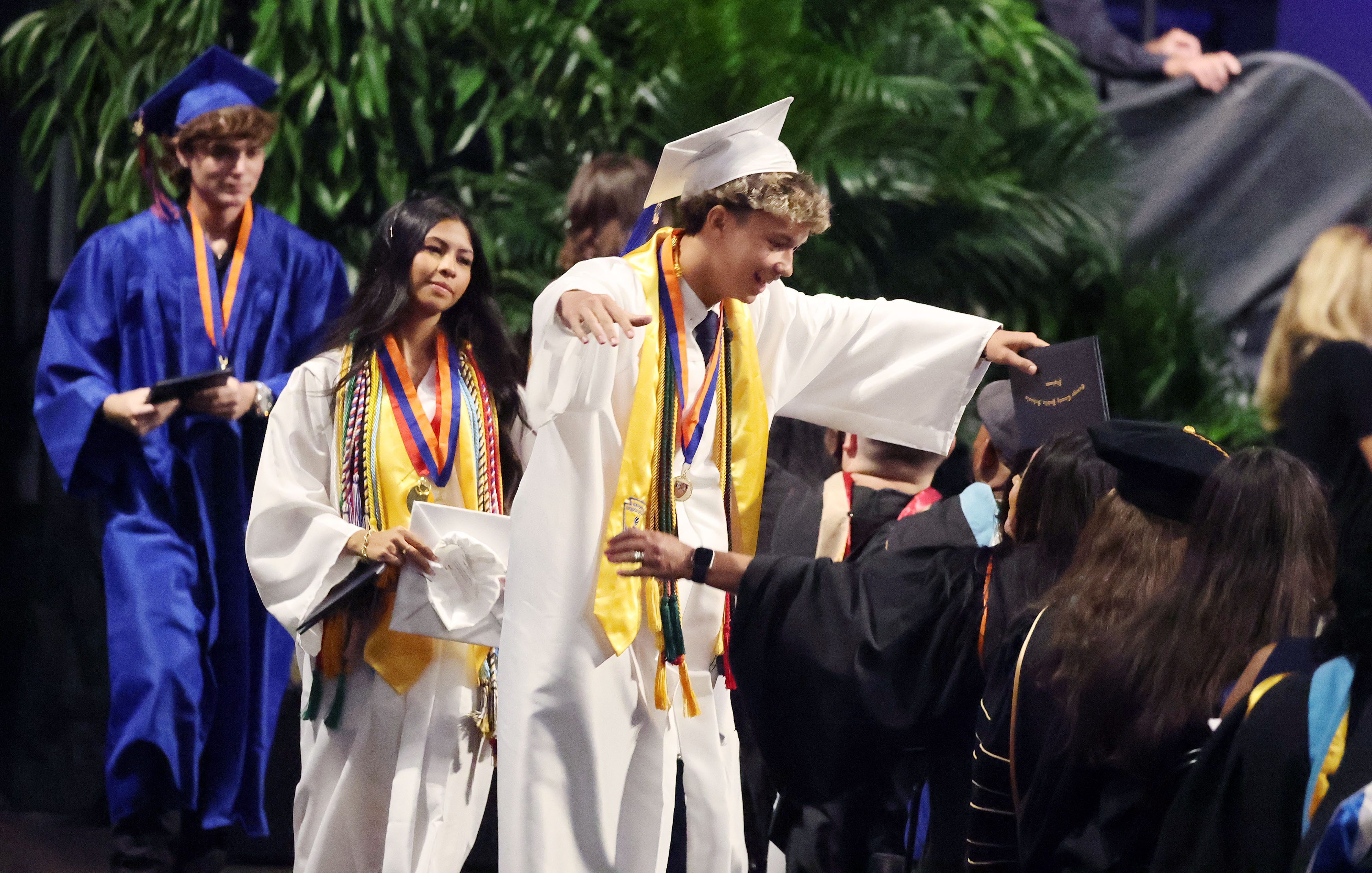 A graduate celebrates after receiving his diploma during West Orange...