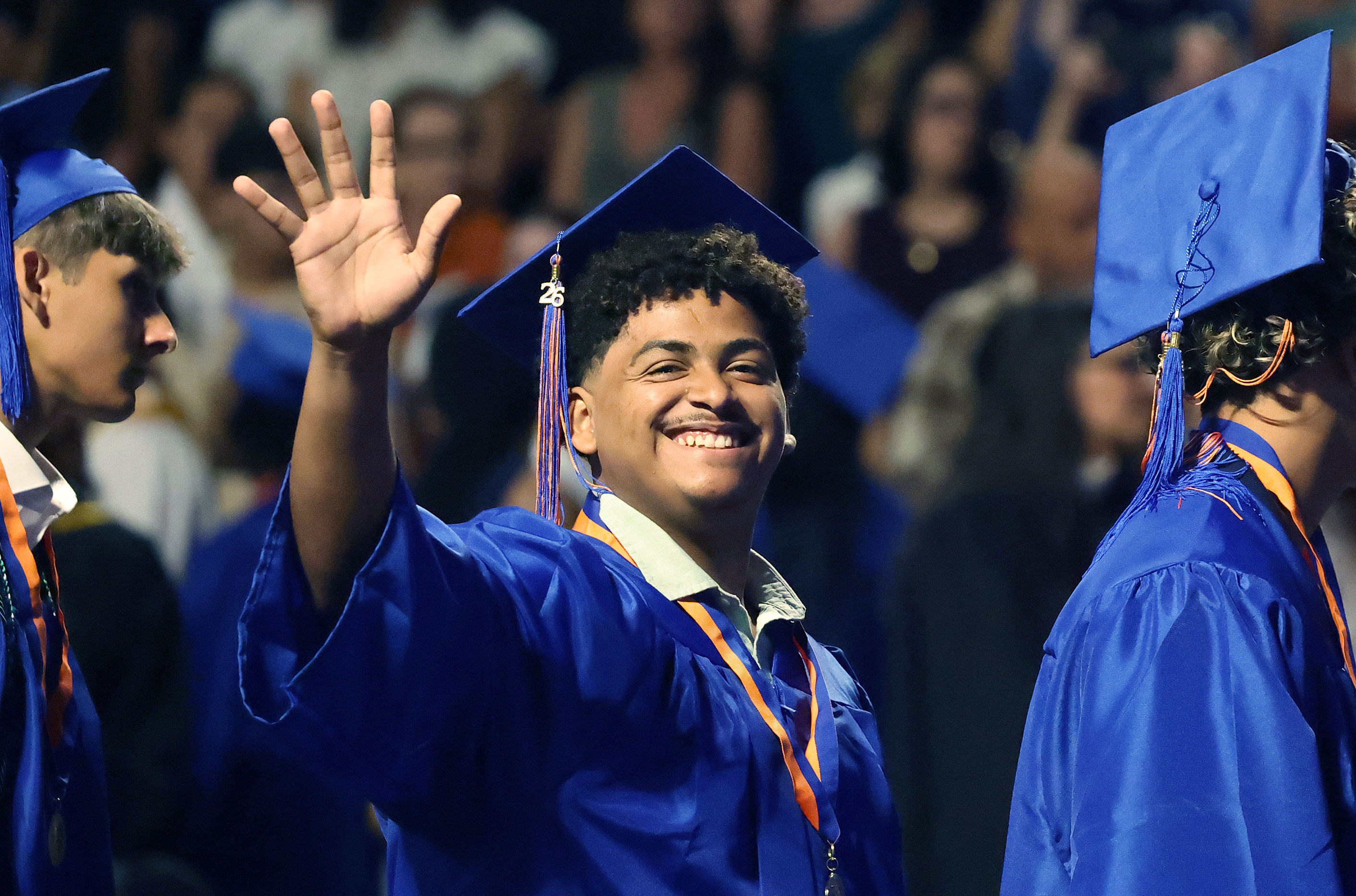 A graduate waves during West Orange High School commencement ceremonies...