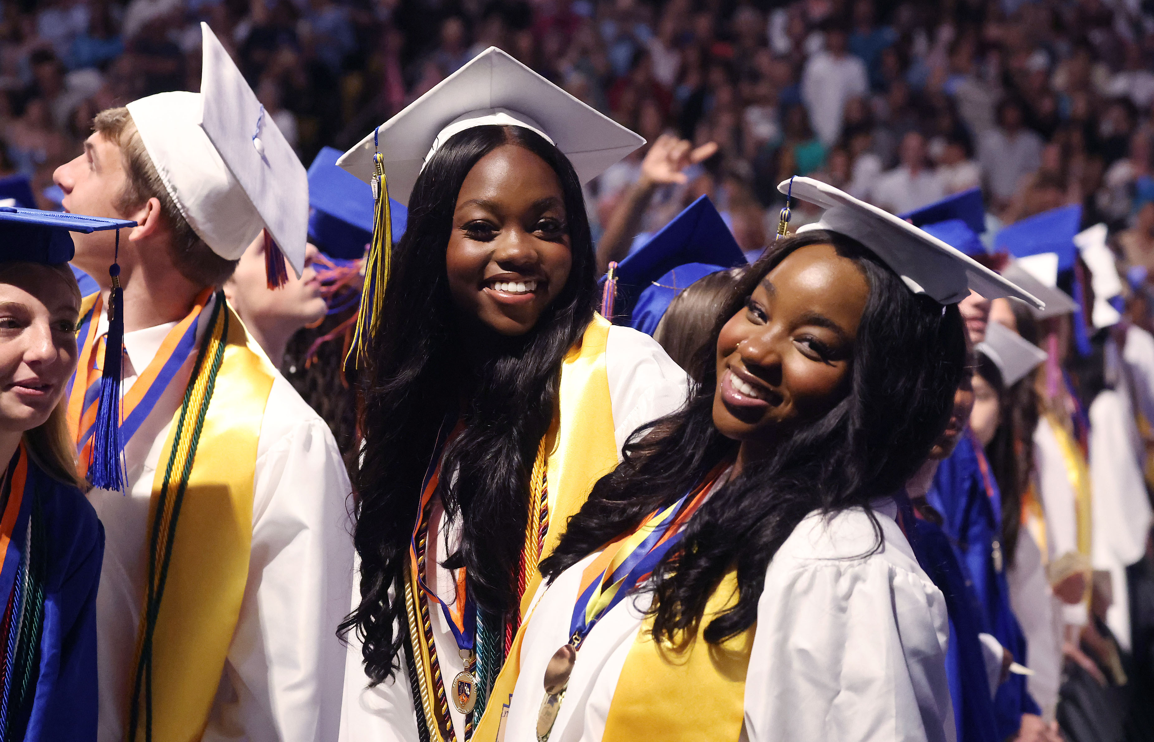 Graduates smile and pose during West Orange High School commencement...