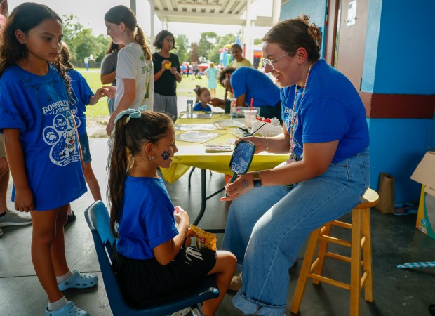 Bonneville Elementary School art teacher Emily Parente reveals a face painting to a student during the Bonneville's Last Bark farewell event for the school on Thursday, May 21, 2026. The East Orange County school is one of the schools closing at the conclusion of the academic year because of declining enrollment. (Rich Pope/Orlando Sentinel)