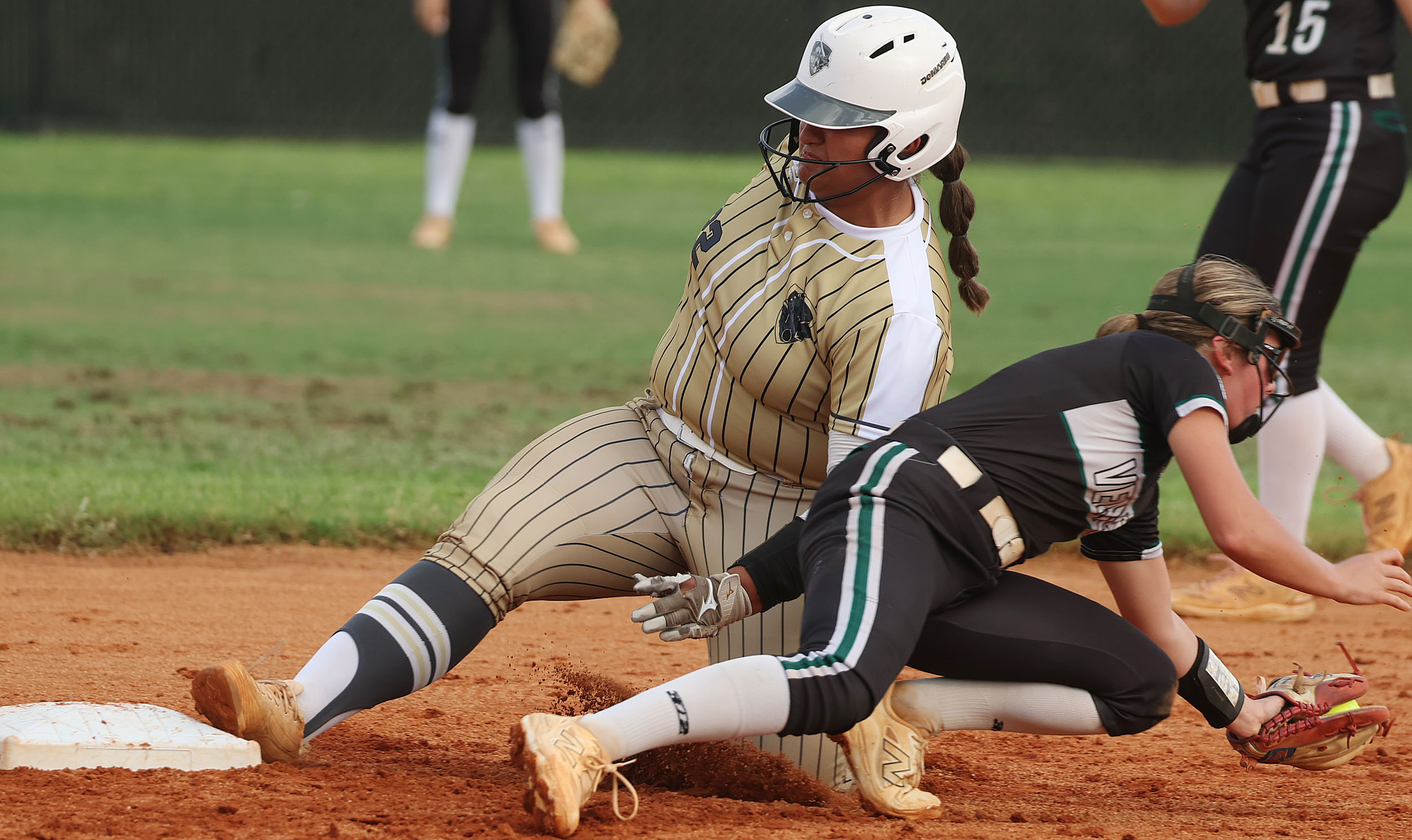 East Ridge High softball player Brianna Santos (left) slides safely...