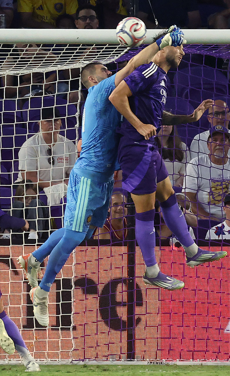 Orlando goalkeeper Maxime Crepeau (left) and Orlando player David Brekalo...