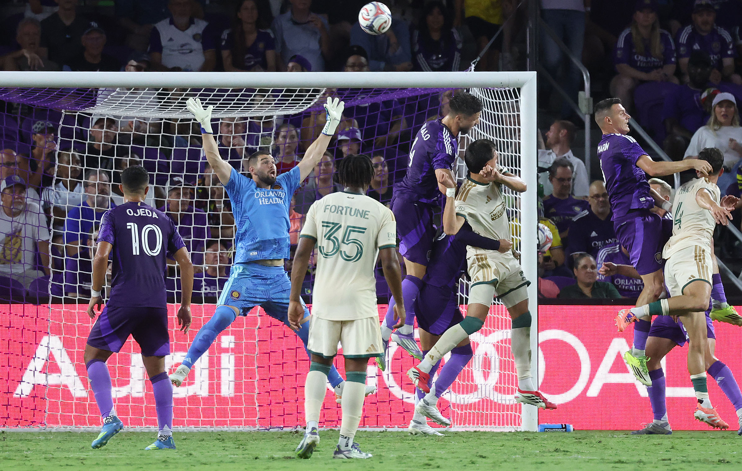 Orlando goalkeeper Maxime Crepeau (arms in air) leaps among players...