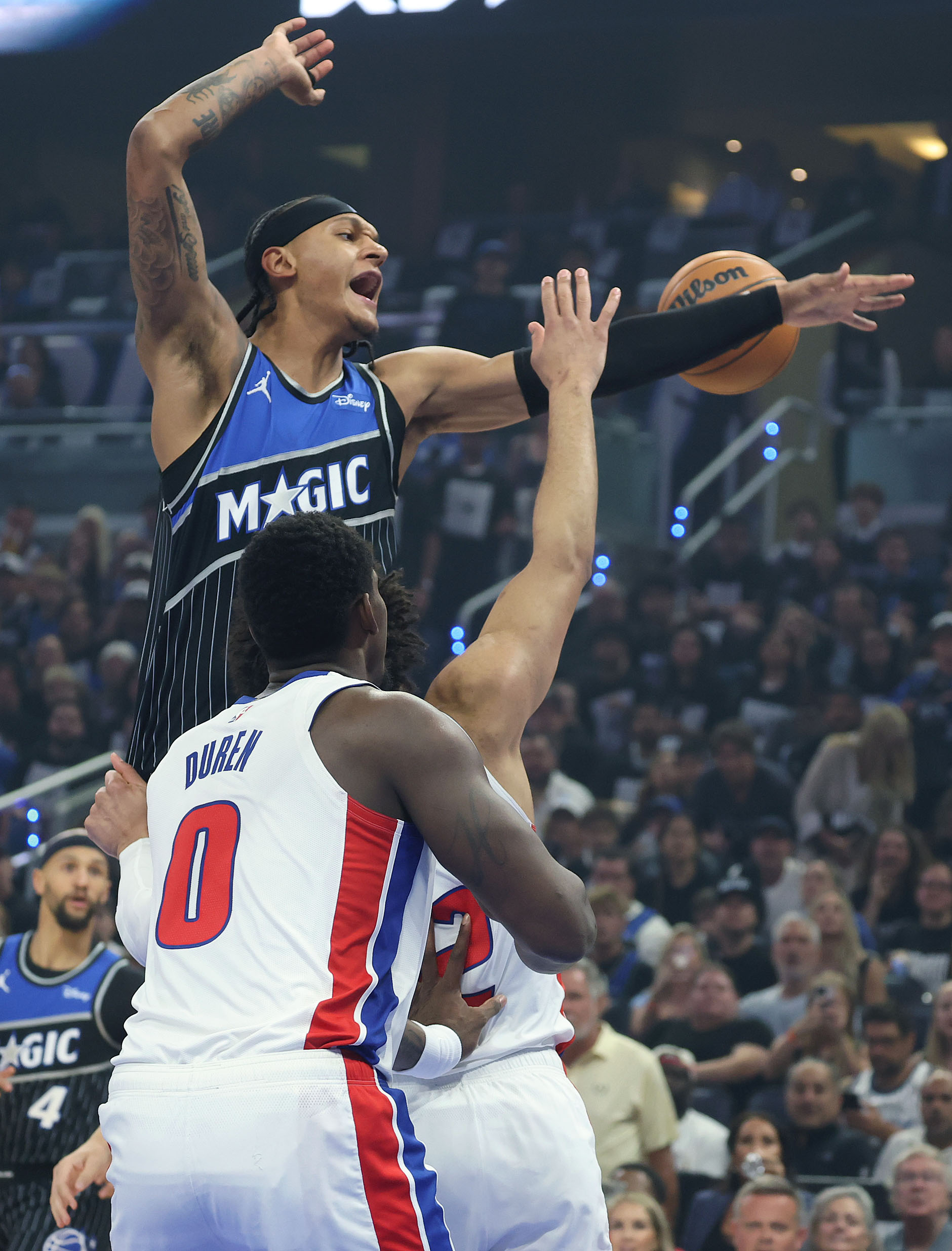 Orlando forward Paolo Banchero (top) leaps over Detroit center Jalen...