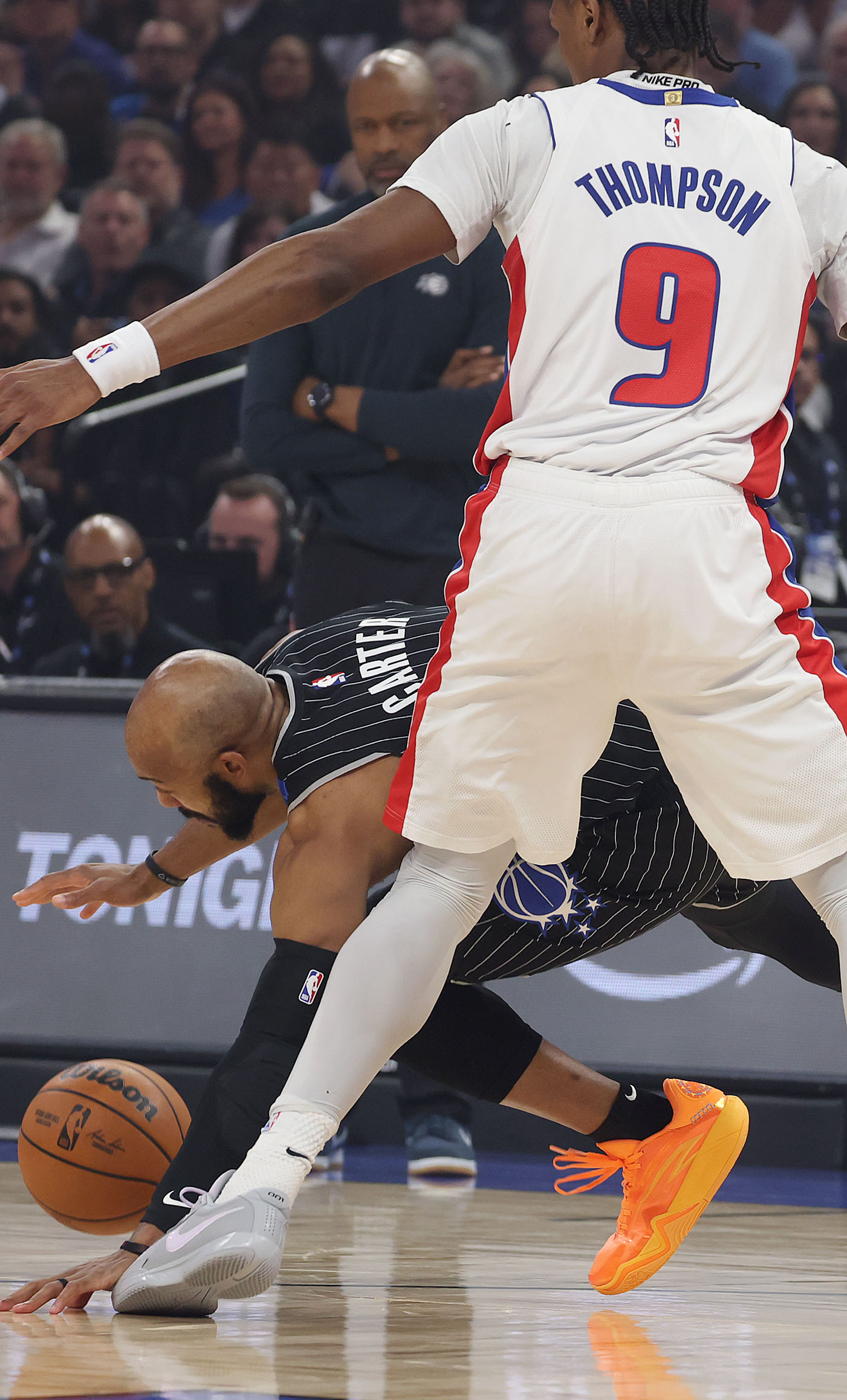 Orlando guard Jevon Carter (bottom) loses the ball under Detroit...