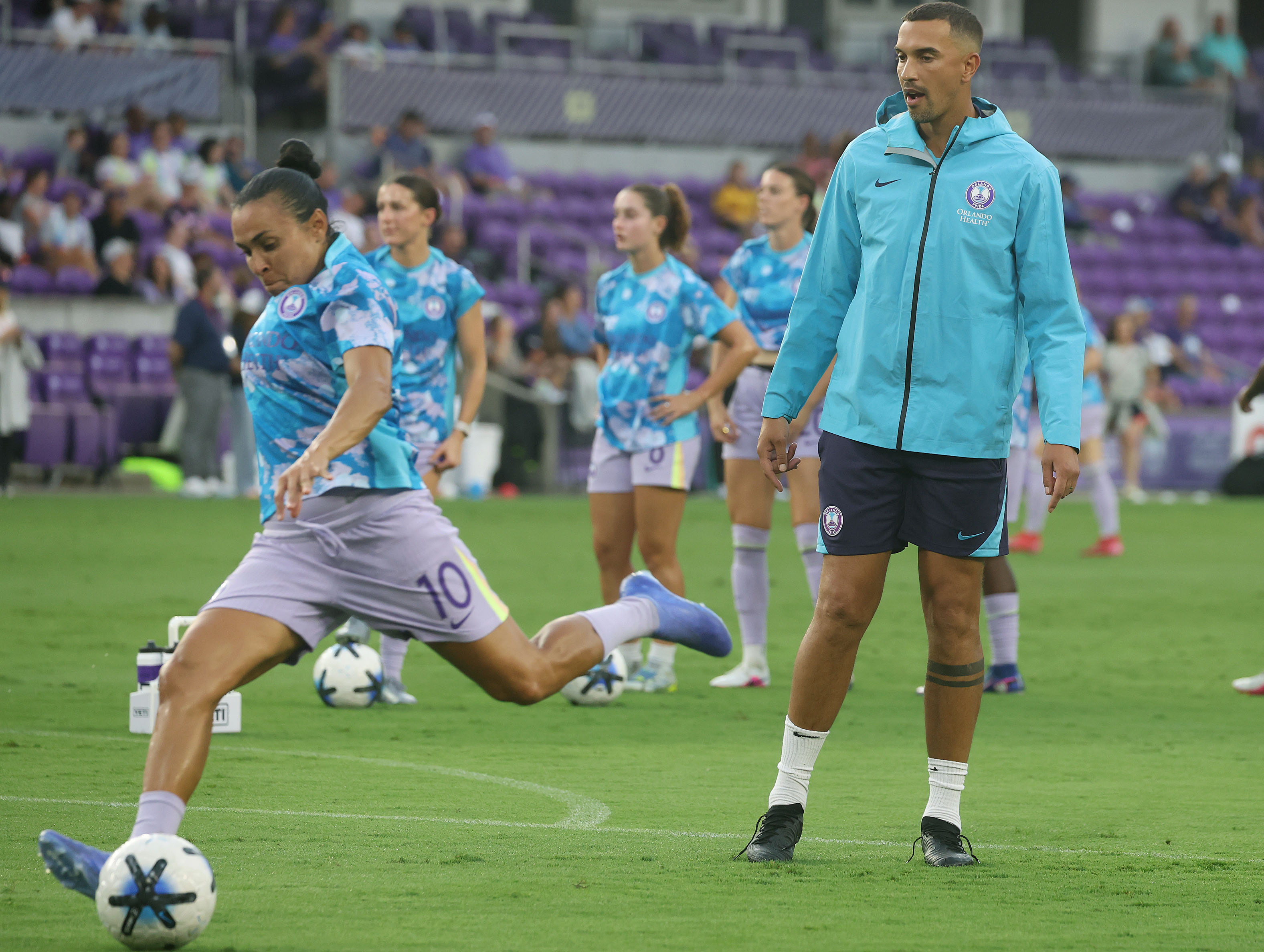 Orlando coach Seb Hines watches Orlando player Marta warm up...