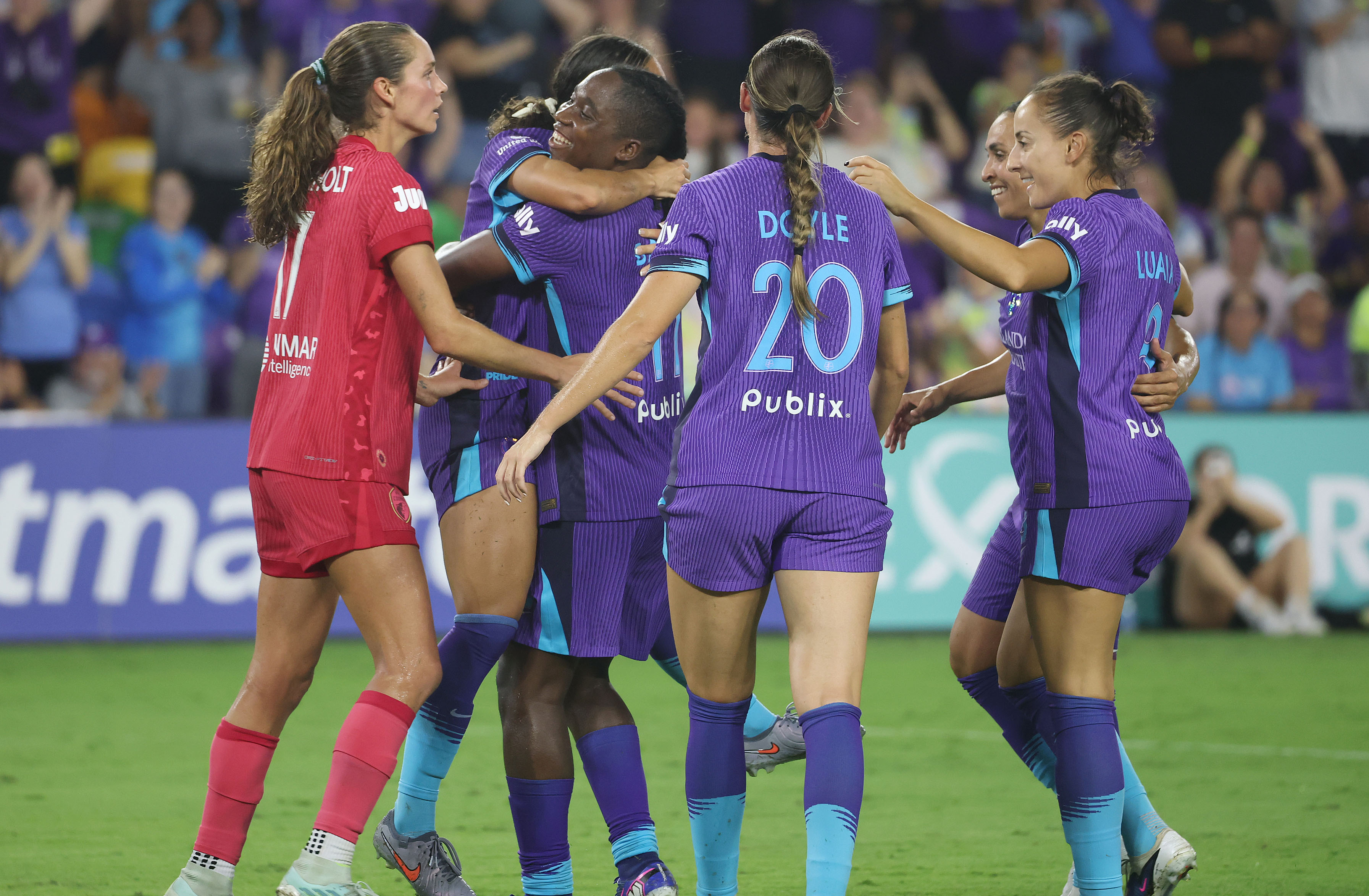 Orlando player Barbra Banda (middle) hugs teammates in celebration after...