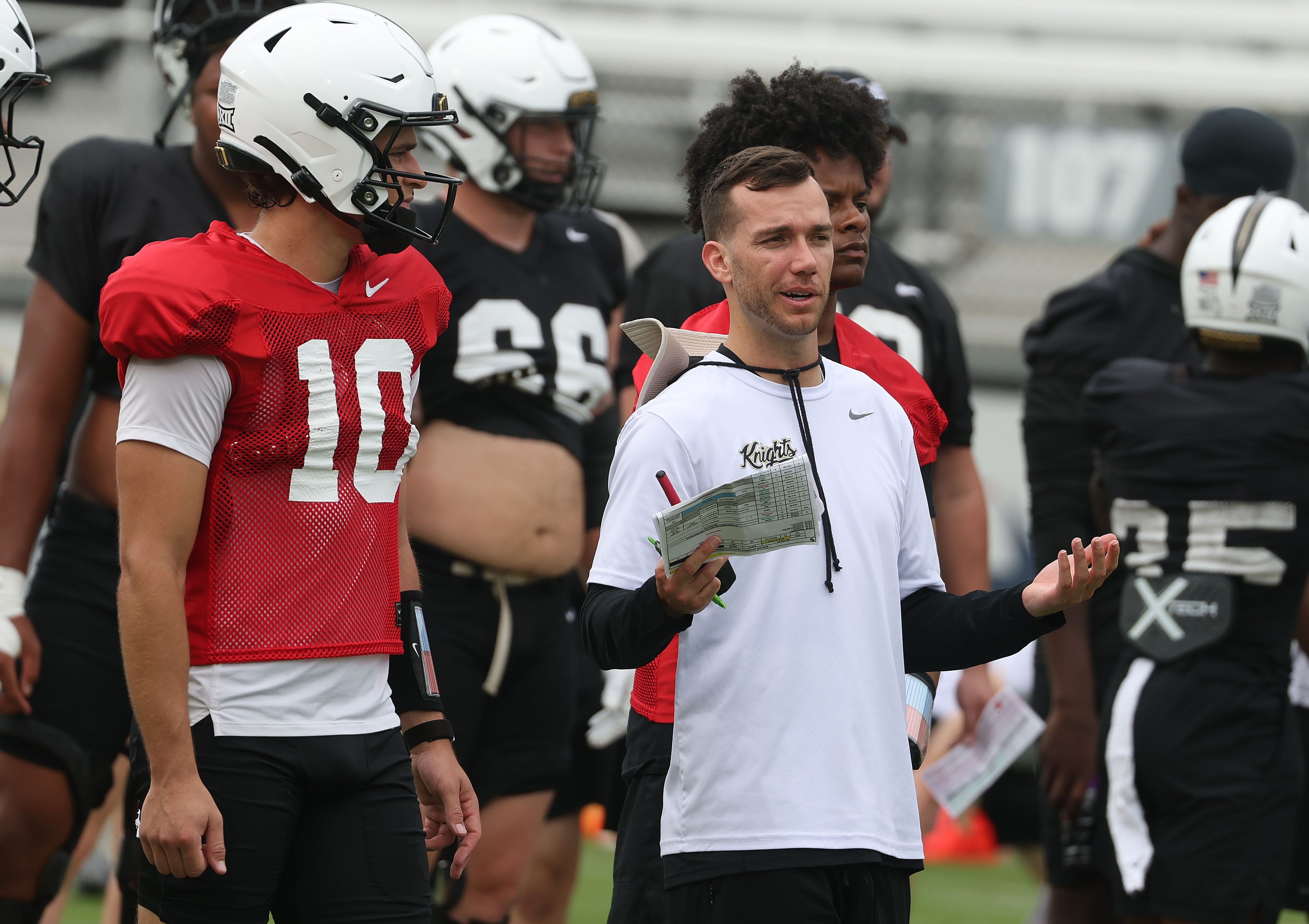 UCF quarterbacks coach McKenzie Milton coaches quarterback Kaleb Annett (10) during UCF practice Saturday at the Acrisure Bounce House Stadium in Orlando. (Stephen M. Dowell/Orlando Sentinel)