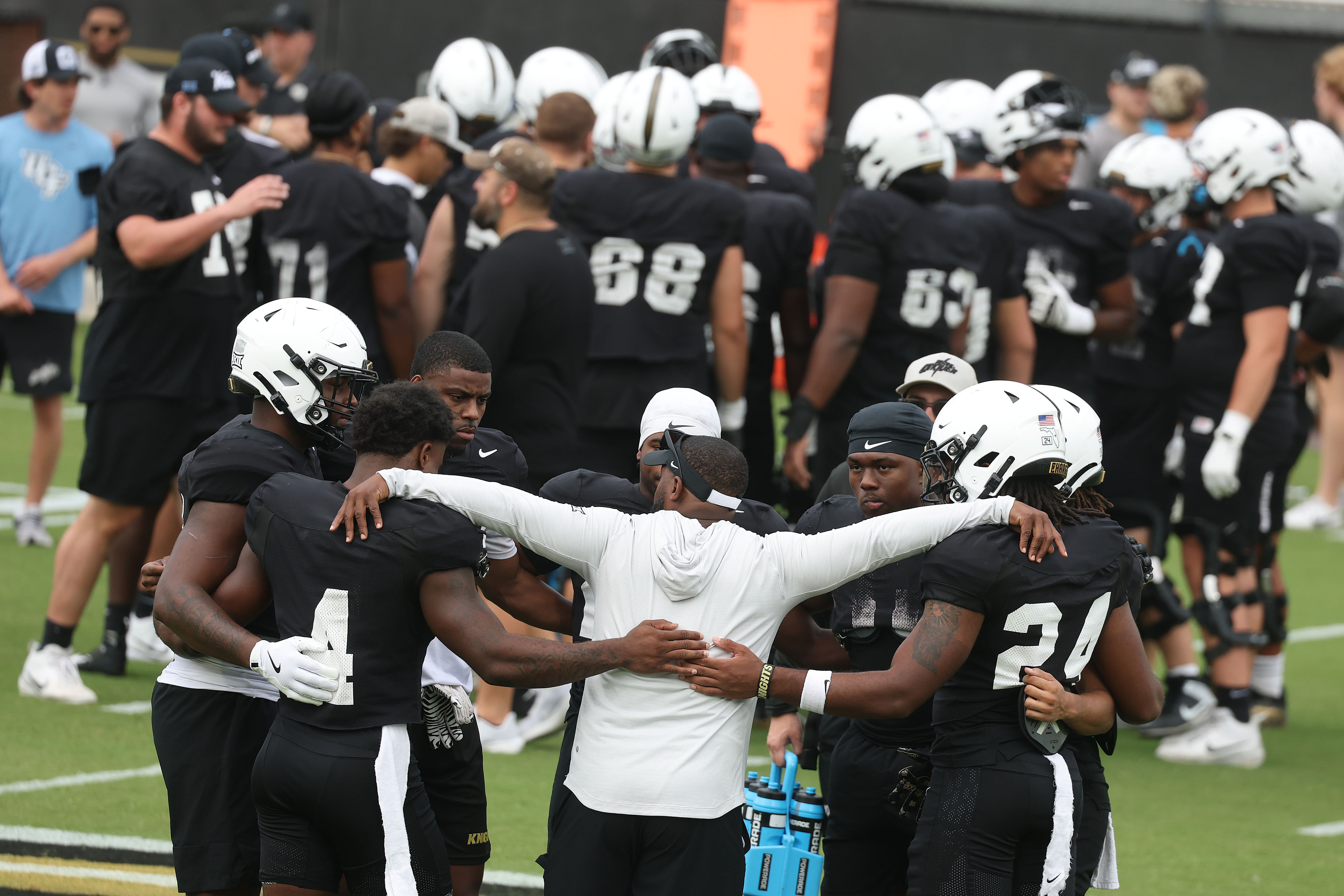 UCF players and coaches huddle during UCF Football Open Practice...
