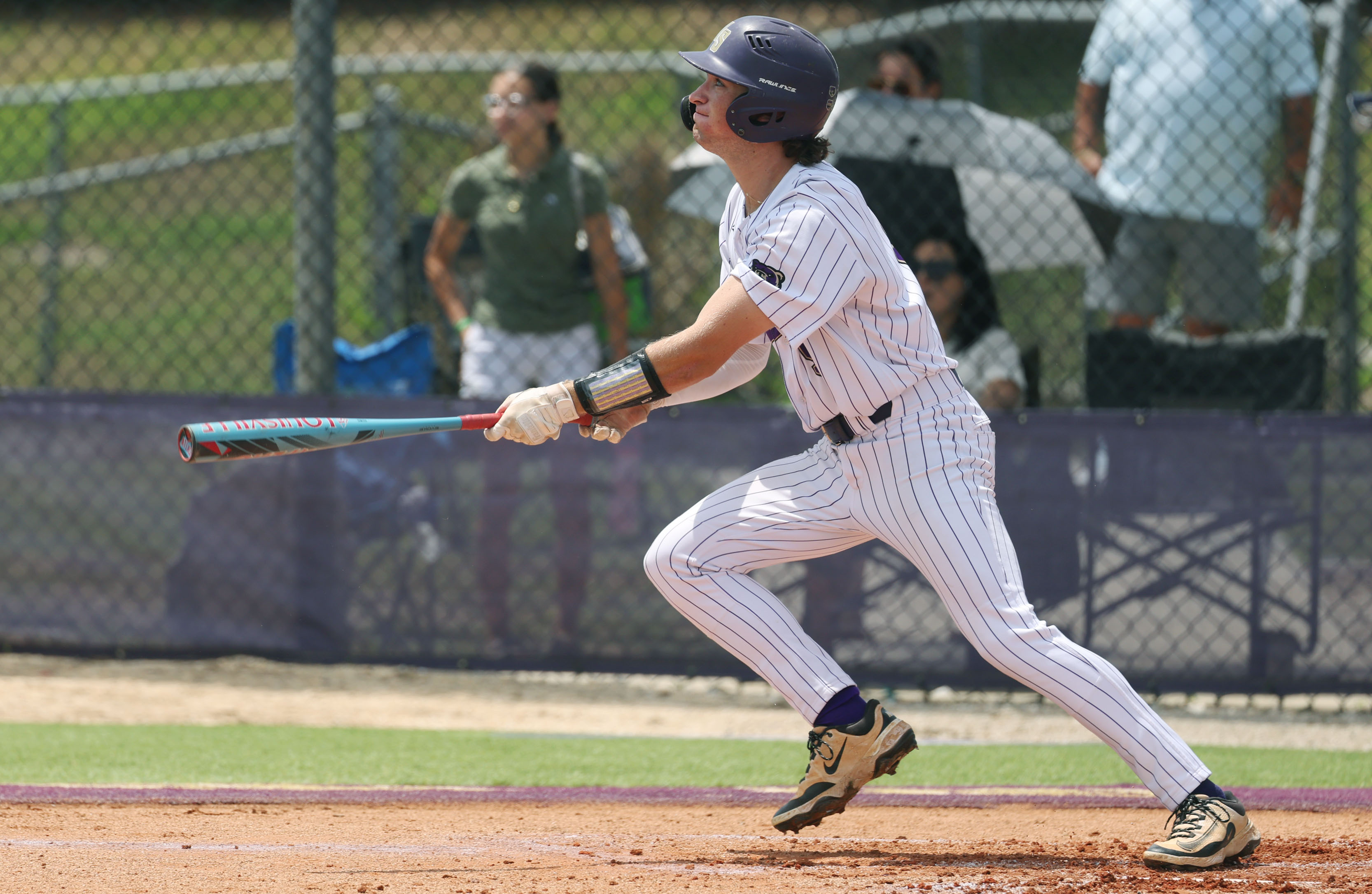 Winter Springs High baseball player Luke Walters watches his hit...