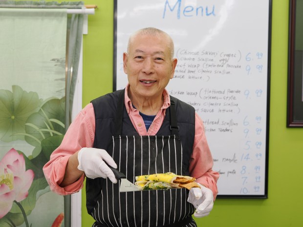 Changkui Tang shows off his wife's delicious handiwork: a jianbing from TT Crepes. (Photo courtesy Lisa Wilk/TasteCookSip.com)