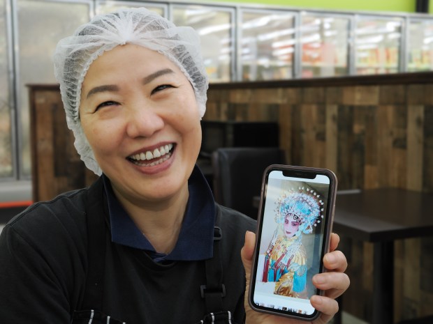 TT Crepes owner Jie Yu shows a photo of herself in costume. For many years, Yu performed traditional Chinese opera at Splendid China near Walt Disney World. (Photo courtesy Lisa Wilk/TasteCookSip.com)