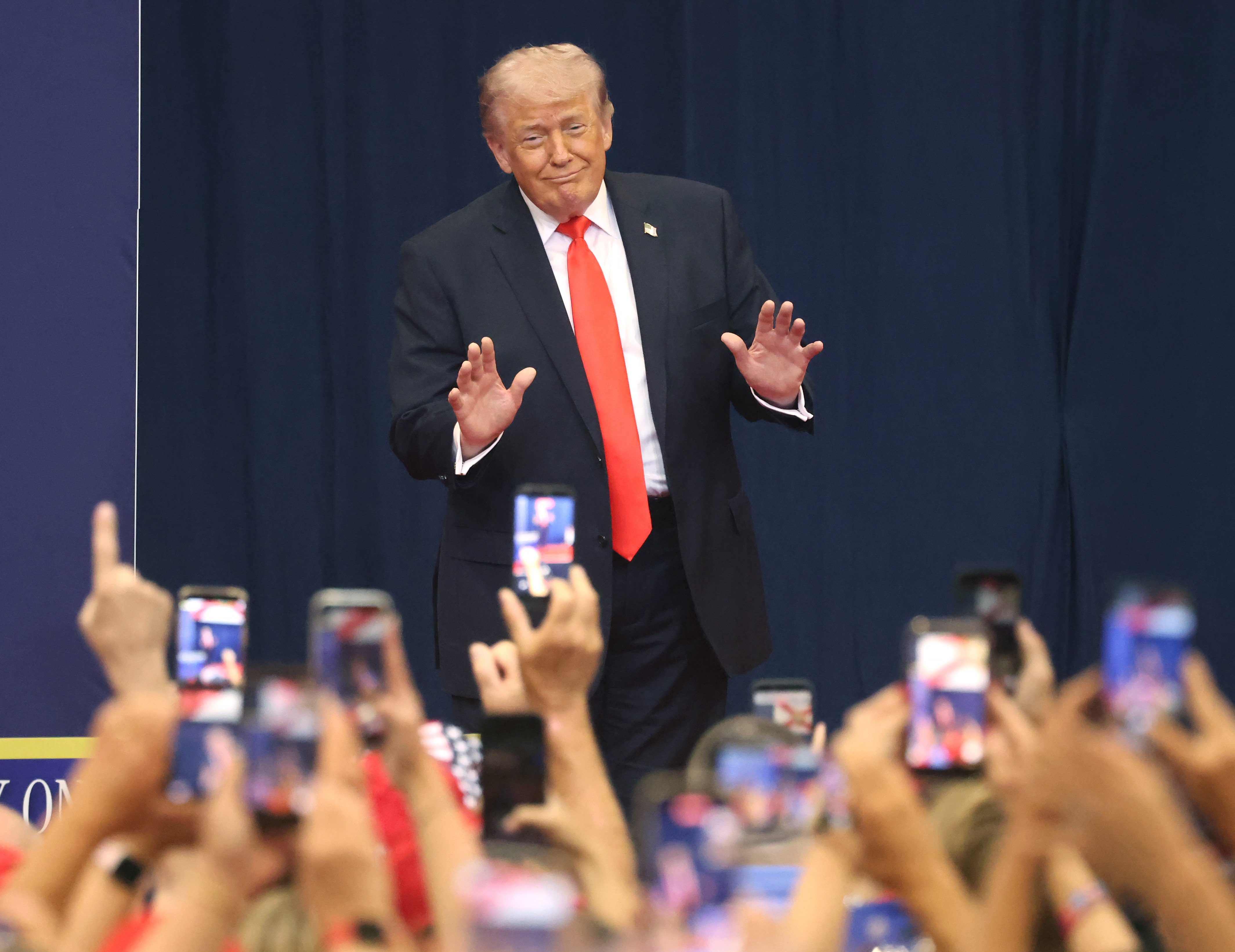 President Donald Trump responds to a cheering crowd as he...