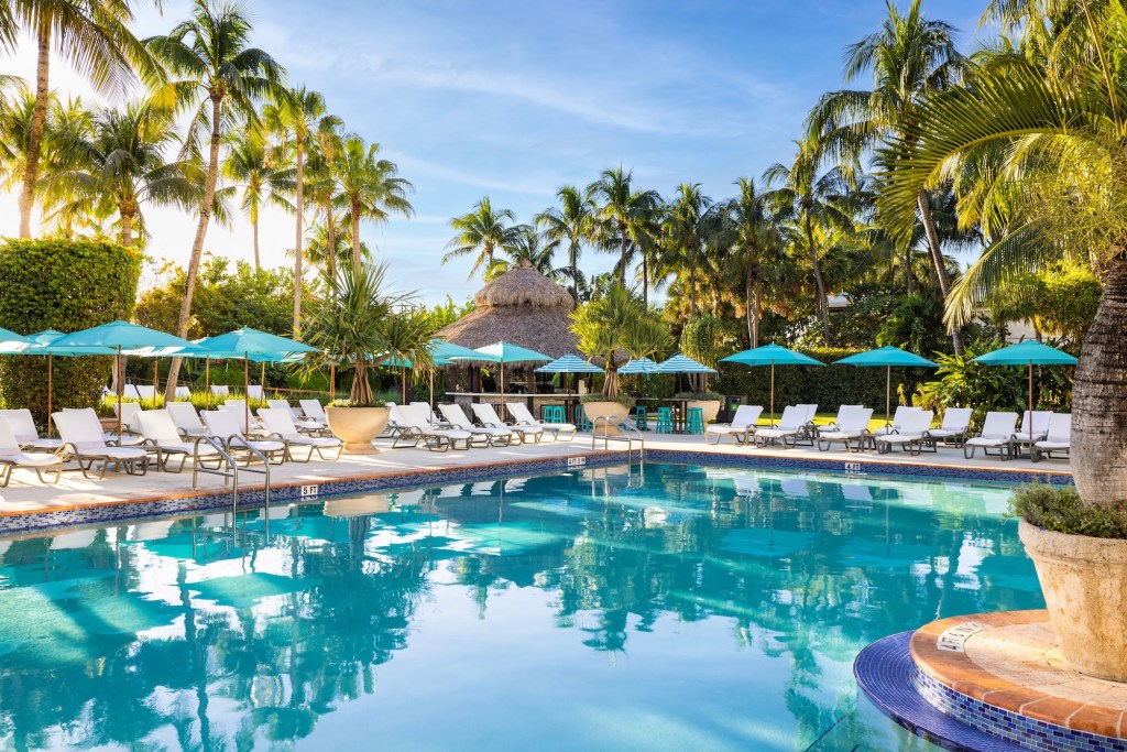 photo of lounge chairs and beach umbrellas around a hotel pool