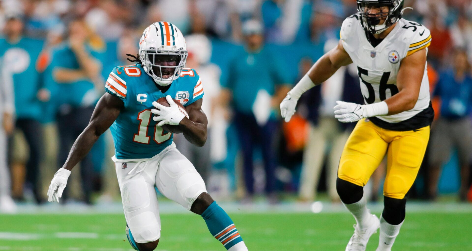 Oct 23, 2022; Miami Gardens, Florida, USA; Miami Dolphins wide receiver Tyreek Hill (10) runs with the football ahead of Pittsburgh Steelers linebacker Alex Highsmith (56) during the first quarter at Hard Rock Stadium.