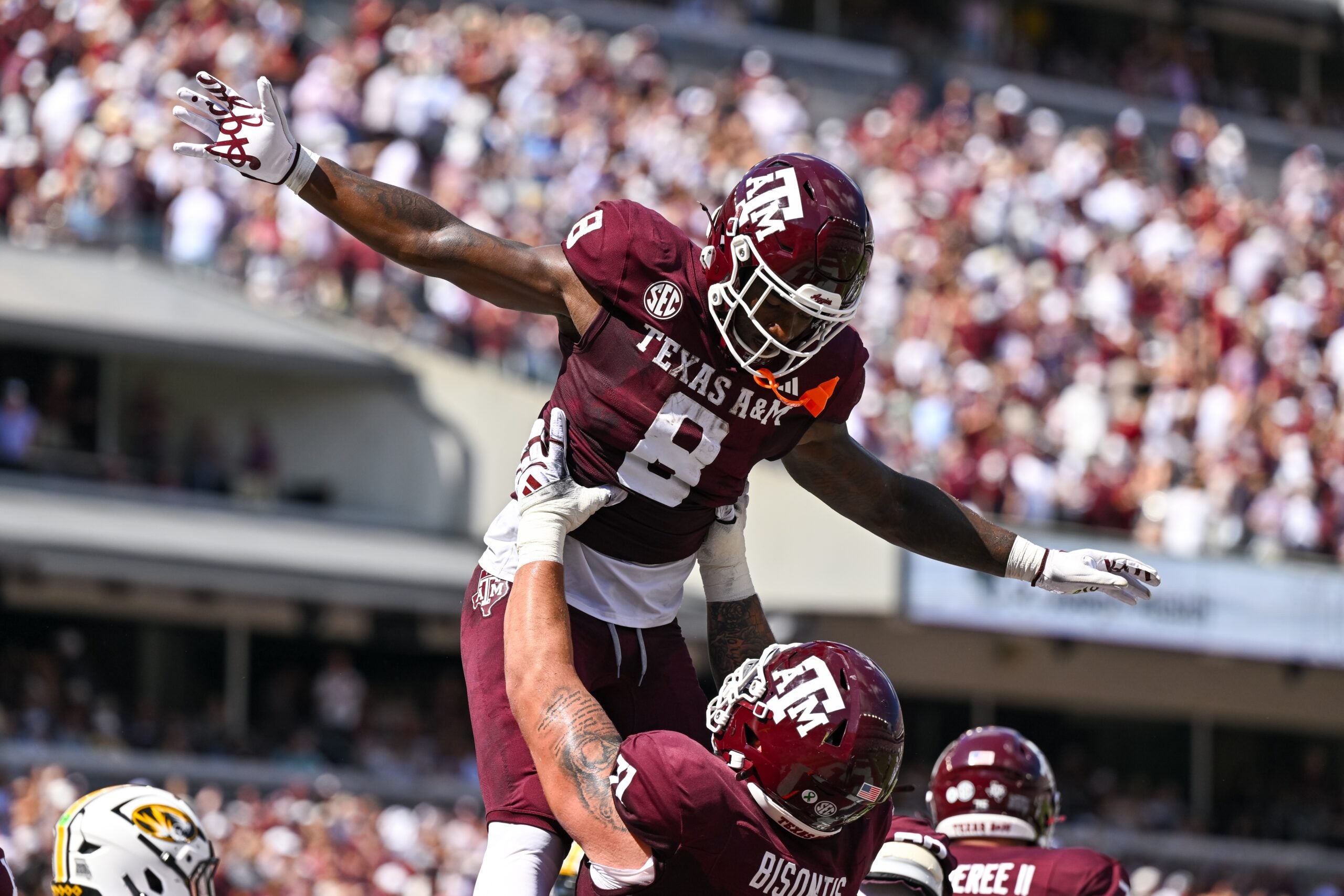 Oct 5, 2024; College Station, Texas, USA; Texas A&M Aggies running back Le'Veon Moss (8) celebrates with offensive lineman Chase Bisontis (71) after scoring a touchdown in the second quarter against the Missouri Tigers at Kyle Field. Mandatory Credit: Maria Lysaker-Imagn Images.