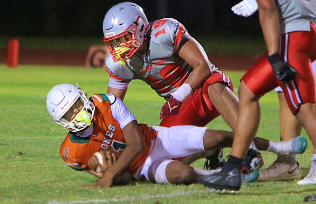 Lake Mary's Aaron Young takes down Jones quarterback Payton Carroll for one of his four sacks Wednesday night in a spring game at Jones. (Chris Hays/Orlando Sentinel)