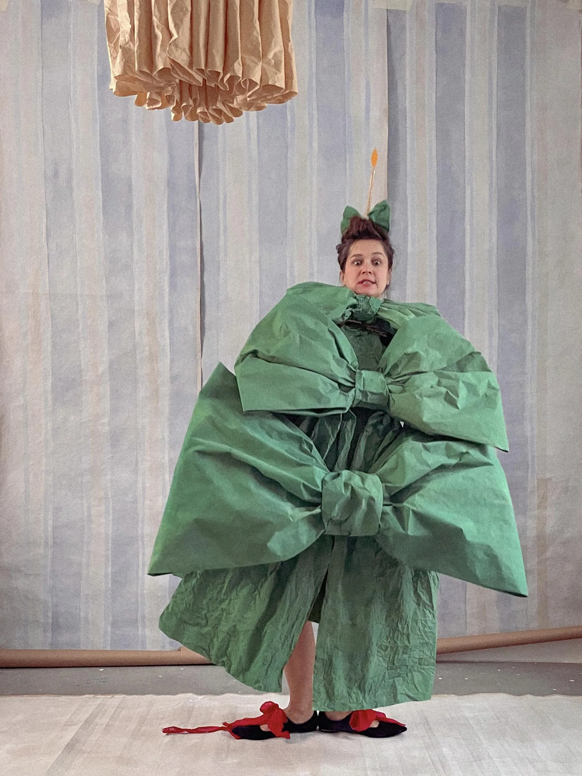 Alla's Nocturnal Visions: Transforming Sheets of Paper into Enchanting Wearable Worlds in St. Petersburg A model wearing a paper dress that cascades elegantly around them.