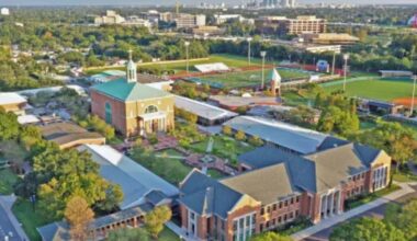Aerial view of Jesuit High School in Tampa showing multiple brick academic buildings, a chapel, athletic fields, and landscaped courtyards.