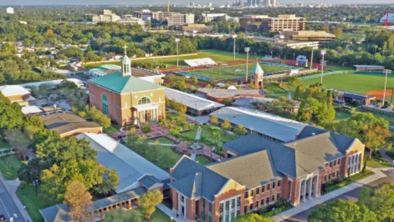 Aerial view of Jesuit High School in Tampa showing multiple brick academic buildings, a chapel, athletic fields, and landscaped courtyards.