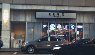 Exterior view of Gen X Tavern in downtown Tampa with illuminated signage and patrons visible inside.