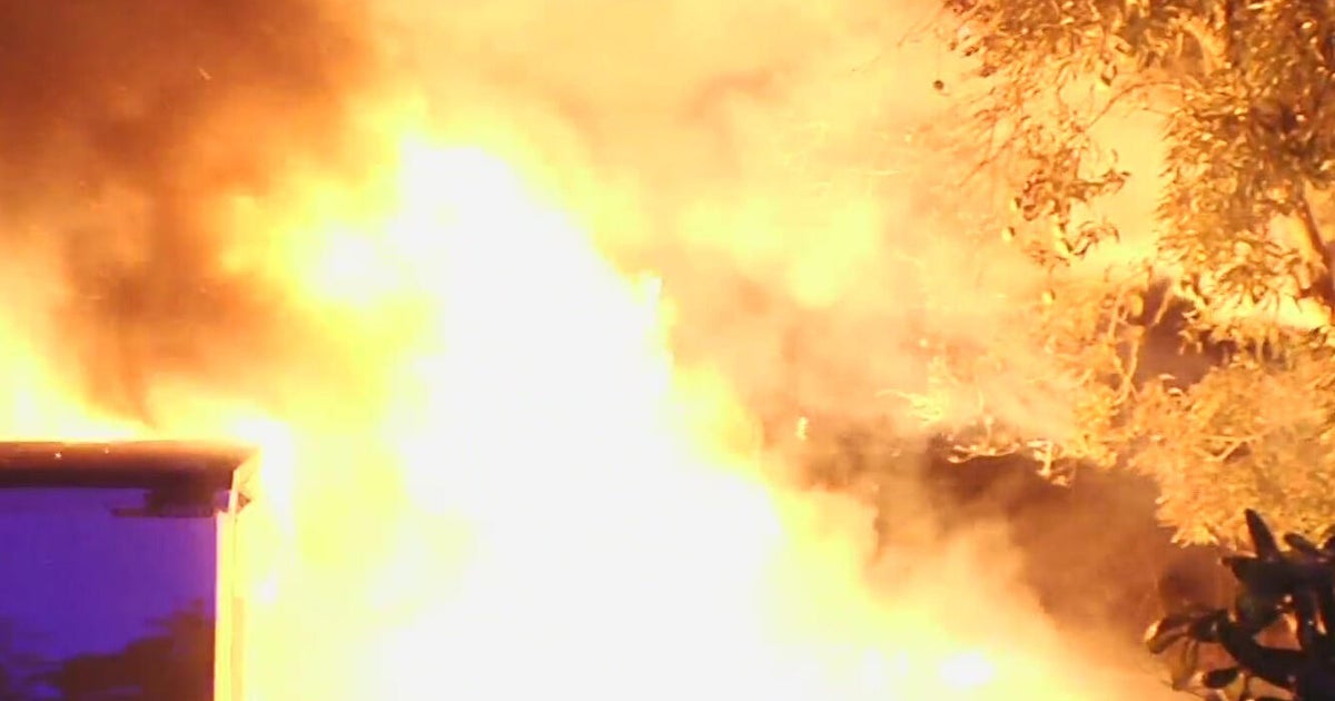 Fire crews race to extinguish massive blaze at RV, home in Northwest Miami-Dade