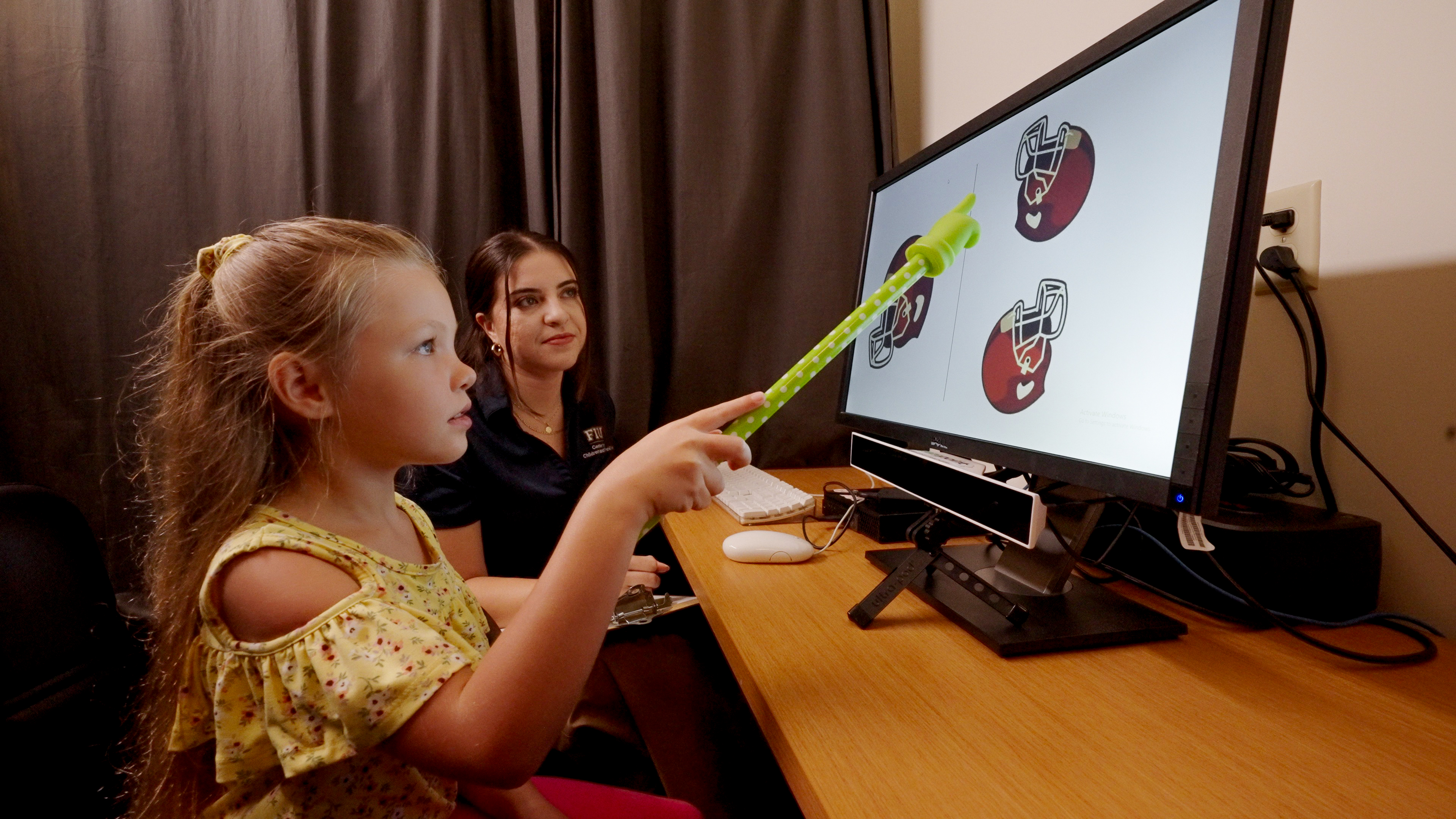 A study participant identifies rotated images on a screen while researcher Karinna A. Rodriguez from FIU's Center for Children and Families guides her.