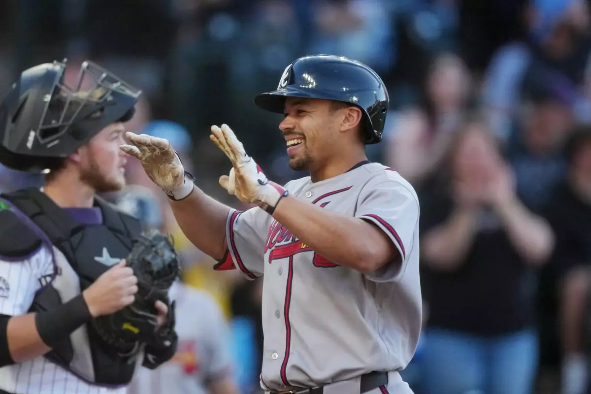Atlanta Braves' Drake Baldwin, right, celebrates as he crosses home plate after hitting a two-run home run off Colorado Rockies starting pitcher Brennan Bernardino in the first inning of a baseball game Saturday, May 2, 2026, in Denver. (AP Photo/David Zalubowski)