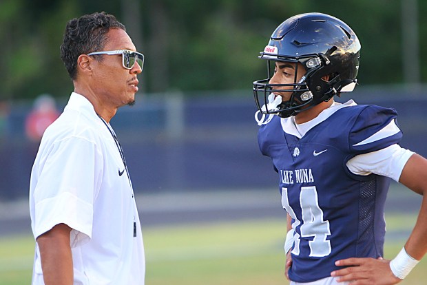 Lake Nona coach David Aubrey talks with his backup quarterback Nick Lora during Thursday night's spring-game victory over Boone. (Chris Hays/Orlando Sentinel)