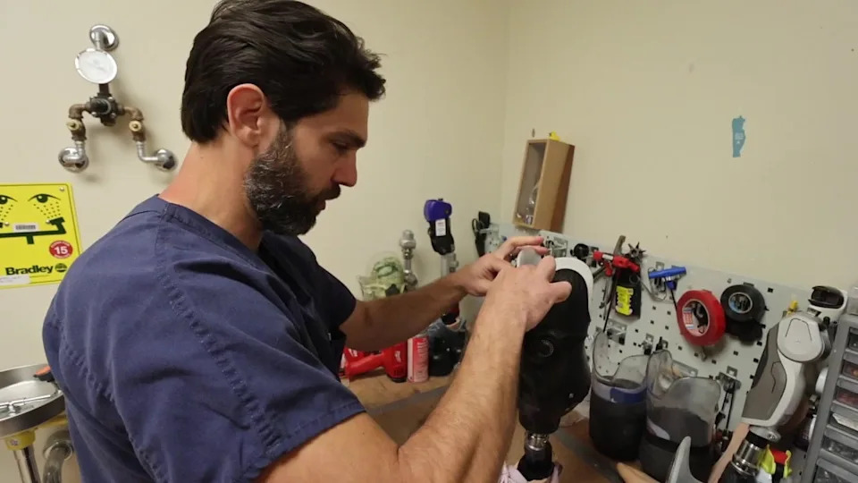 <div>A prosthetist at the center molds a new limb by hand; every device is built from scratch to meet the veteran's specific needs.</div>