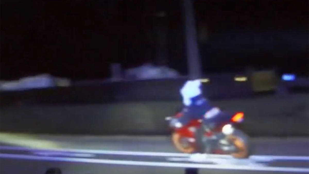 Motorcyclist wearing a bunny helmet riding on a highway