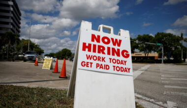 FILE PHOTO: A "Now Hiring" sign advertising jobs at a hand car wash is seen in Miami