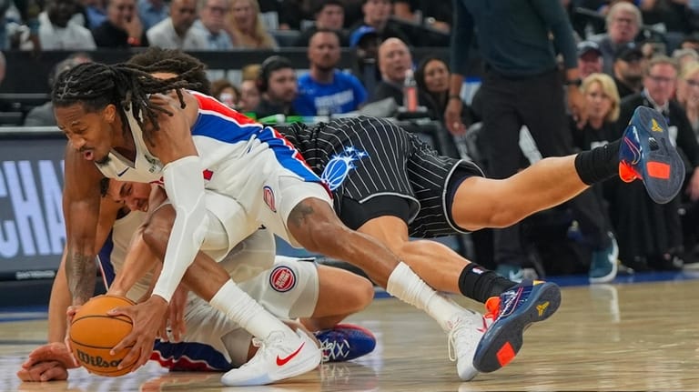 Detroit Pistons guard Daniss Jenkins, left, fights for a loose...