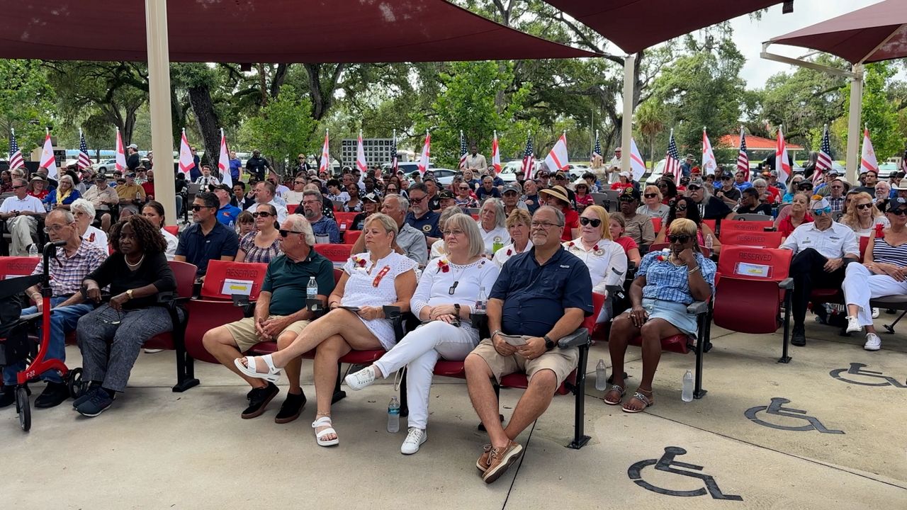 Dozens of people listen to speakers at Veterans Memorial Park in Tampa. (Spectrum News)