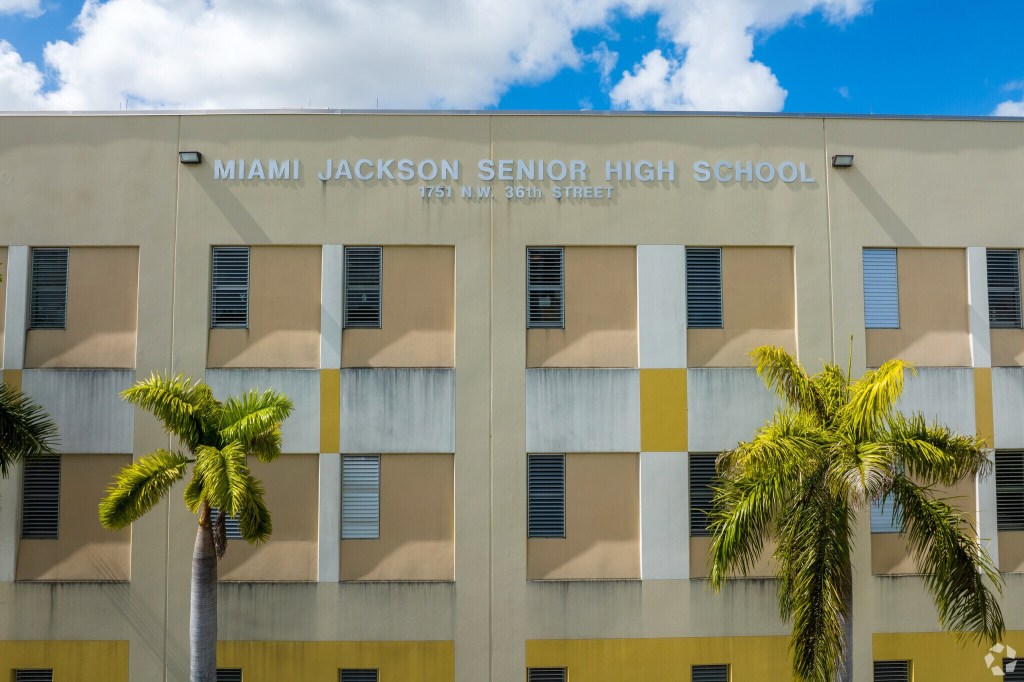 Miami Jackson Senior High School building with palm trees.