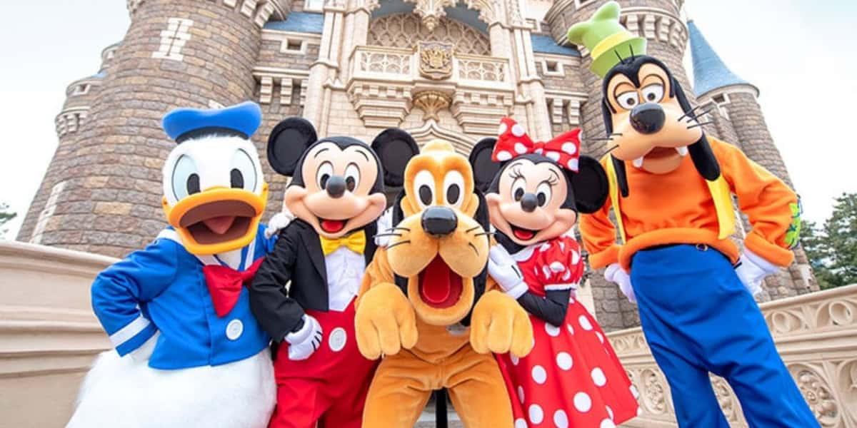 A group photo of Disney Resort characters in front of Cinderella Castle. From left to right: Donald Duck, Mickey Mouse, Pluto, Minnie Mouse, and Goofy. A Disney Cruise Line Japan is coming soon.
