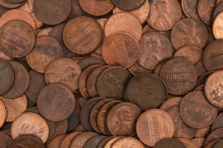 Here are a few options for SEO-friendly alt text for this photo, depending on the specific focus of the article or page you are placing it on: Option 1: Focus on Budgeting & Saving (Best for financial blogs) Alt text: Close-up background of a pile of United States copper pennies, symbolizing budgeting, personal finance, and saving money.