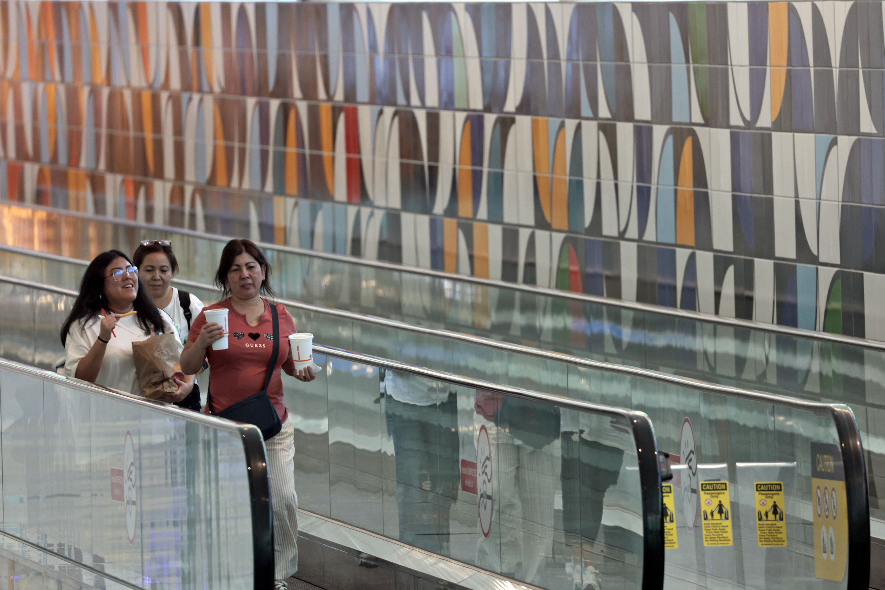 Pedestrians pass âCentro de Formacao,â a 198-foot ceramic tile mural...
