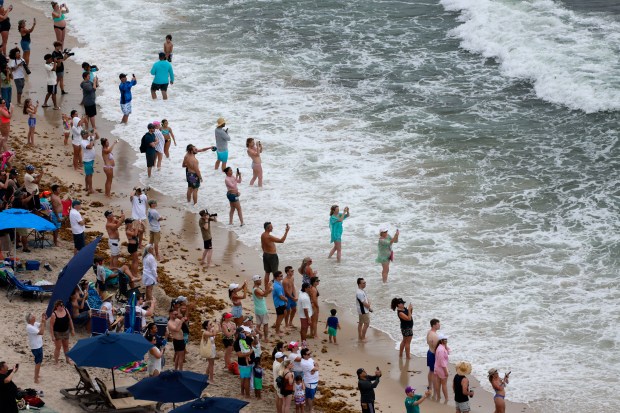 Beachgoers watch the U.S. Navy Blue Angels perform in the Fort Lauderdale Air Dot Show Tour on Saturday May 3, 2025. The show continues on Sunday, May 4, 2025 over Fort Lauderdale Beach. (Mike Stocker/South Florida Sun Sentinel)